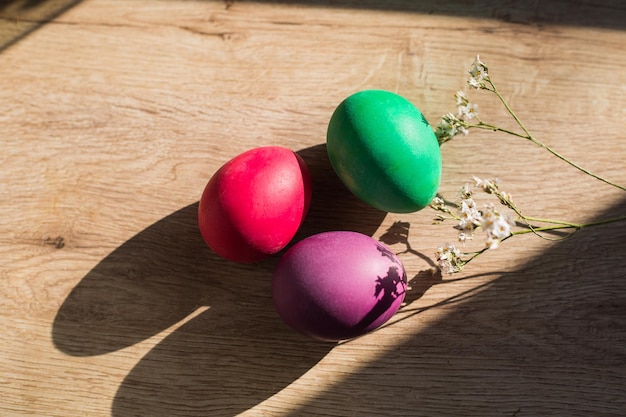 Bunt bemalte Ostereier liegen auf einem Holztisch Dekoration Ostern Frühling Osterdeko hartes Licht