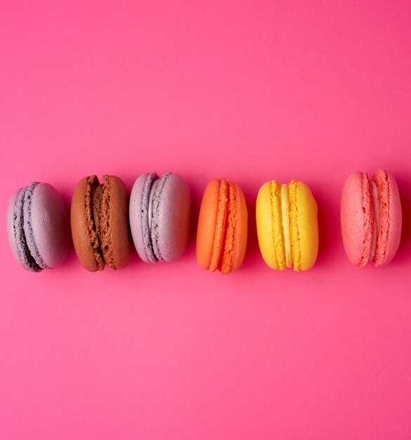 Bunt gebackenes Macarons-Mandelmehl auf einem rosa Hintergrund