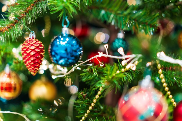 Foto bunt vom glänzenden weihnachtsornament verziert auf grünem x'mas baum