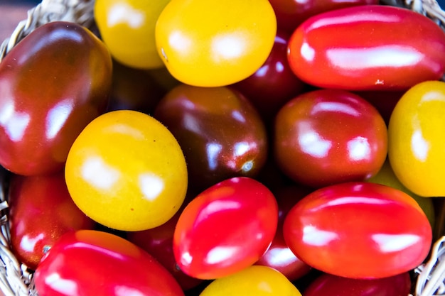 Bunt von frischen, roten und gelben Kirschtomaten im Vordergrund.