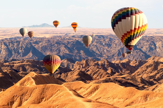 Bunte Ballons, die über den Mondtalberg fliegen. Afrika. Namibia.