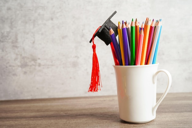 Bunte Bleistifte im Glasgefäß mit Kopienraum, der Hochschulbildungskonzept lernt