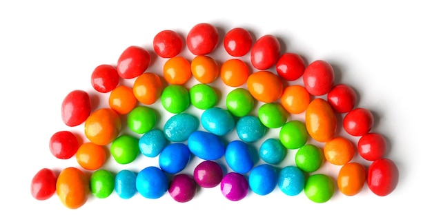 Bunte Bonbons, die als Regenbogen einzeln auf Weiß angeordnet sind