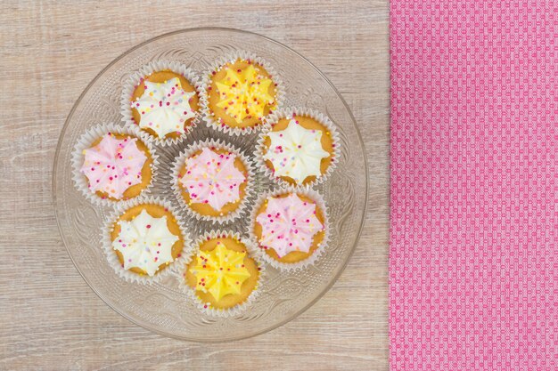 Bunte Cupcakes auf einem weißen Holz Hintergrund. Draufsicht mit Platz für Ihren Text.