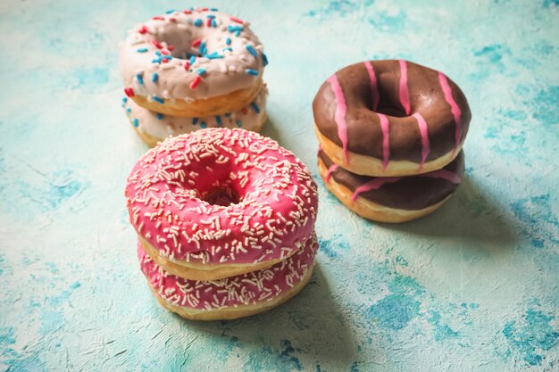 Bunte Donuts auf blauem Steintisch. Draufsicht