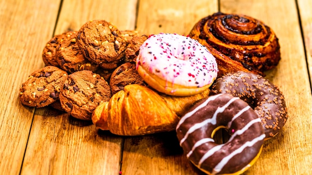 Bunte Donuts auf einem Holztisch Süßes Zuckergerät mit glasiertem Sprengsel Donut mit Schokoladenglasur Top-View mit Kopierplatz