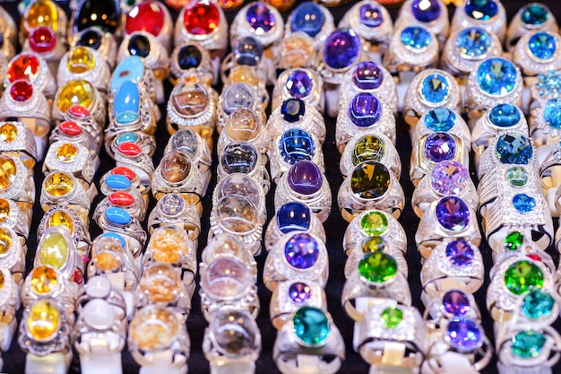 Bunte Edelsteinringe auf dem Tisch auf dem Markt, die früher Finger für Schönheit trugen.