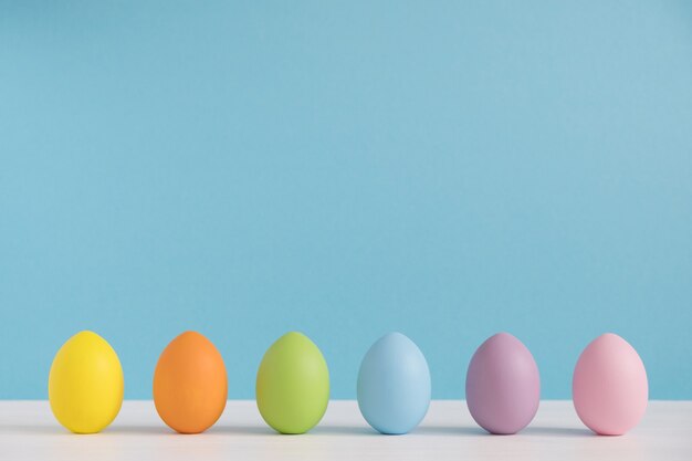 Bunte Eier auf hellblauem Hintergrund. Frohe Ostern Hintergrund. Minimale Ostern. Regenbogenfarbe