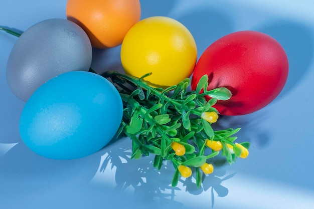 Bunte Eier, die Ostern auf einem bunten Hintergrund und Blumen symbolisieren