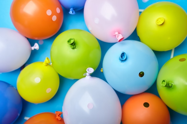 Bunte Feierspaßballone auf blauem Hintergrund. Partyfarbenballons einfache Draufsicht