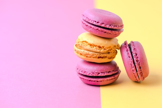 Bunte französische Macarons auf Gelb mit rosa Hintergrund