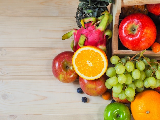 Bunte frische Obst und Gemüse auf hölzernem Hintergrund, Konzept der gesunden Ernährung.