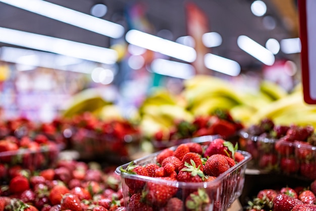 Bunte Früchte und Beeren auf dem Bauernmarkt, Bananen und Erdbeeren, die im Supermarkt verkauft werden ...