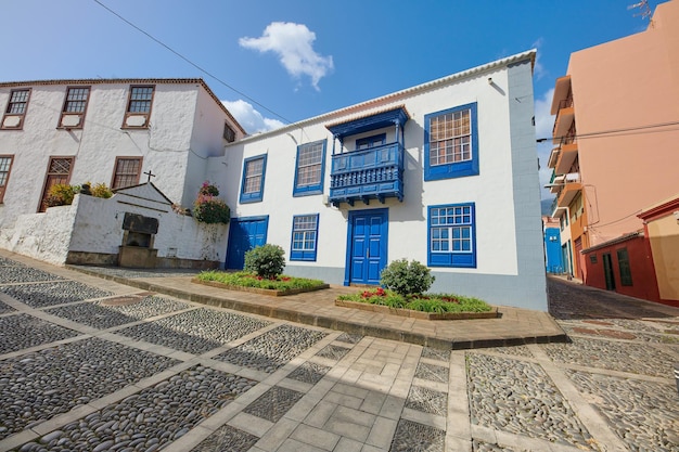 Bunte Häuser mit traditionellem Design in der Stadt Santa Cruz de La Palma Straße in einer kleinen Altstadt oder einem Dorf mit hellen und lebendigen Wohngebäuden an einem bewölkten Sommertag