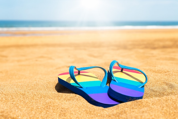 Bunte Hausschuhe am Strand an einem Sommertag Flip-Flops mit Gay-Pride-Flagge