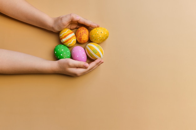 Bunte hölzerne Ostereier in Kinderhänden nach der Eiersuche