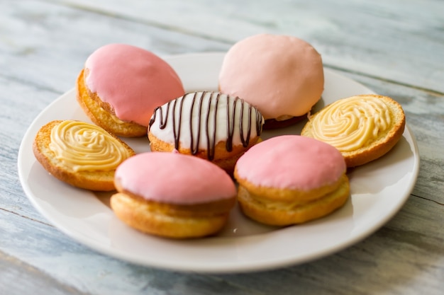 Bunte kekse auf einem teller. kekse mit zuckerguss. buschkuchen mit vanillepuddingfüllung. traditionelle süßigkeiten aus knusprigem teig.