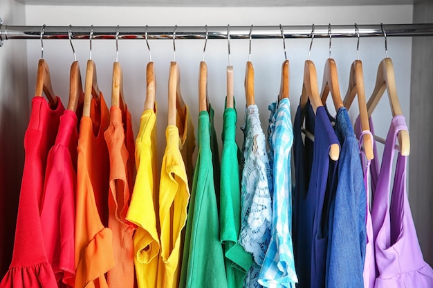 Bunte Kleidung auf Kleiderbügeln im Kleiderschrank