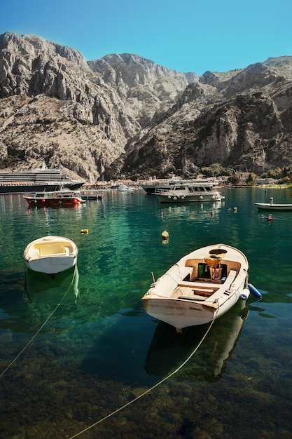 Bunte Landschaft mit Booten, Kreuzfahrtschiff und Yachten in Marina Bay, Meer, Bergen, blauem Himmel. Draufsicht der Bucht von Kotor, Montenegro