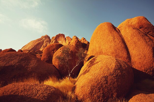 Bunte Landschaften der orangefarbenen Felsen in den Spitscoppe-Bergen in Namibia an einem sonnigen heißen Tag.