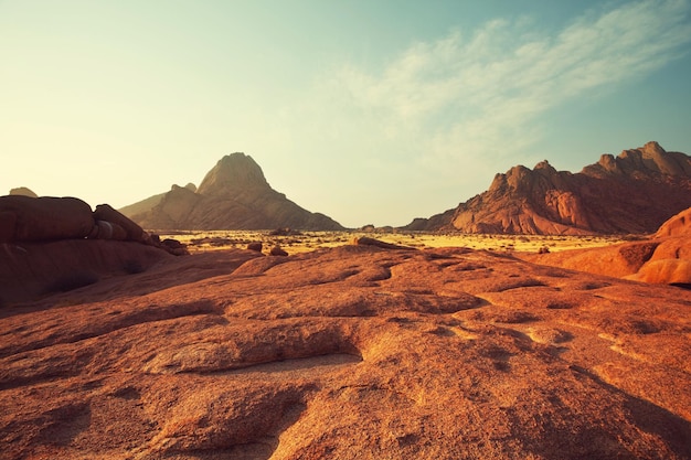 Bunte Landschaften der orangefarbenen Felsen in den Spitscoppe-Bergen in Namibia an einem sonnigen heißen Tag.