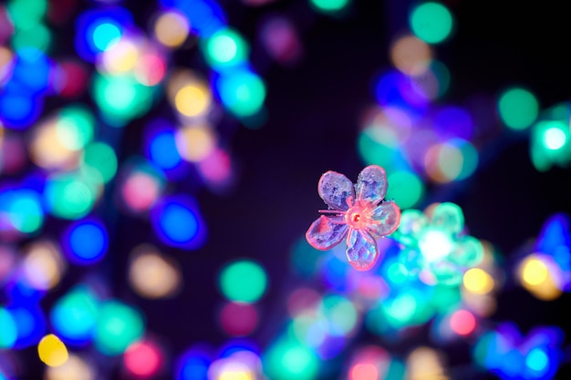 Bunte Lichter Bokeh von dekorativen leuchtenden Blumengirlanden im Urlaub mehrfarbige Lichter