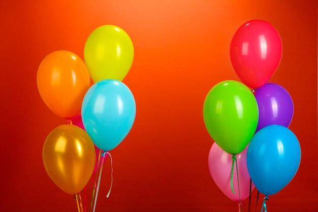 Bunte Luftballons auf rotem Hintergrund