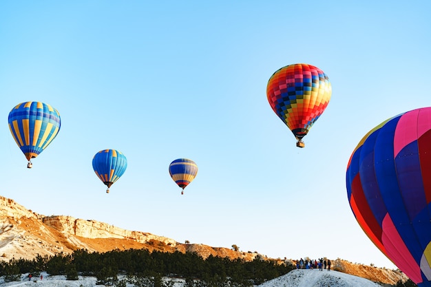 Bunte Luftballons fliegen im klaren Himmel nahe dem riesigen weißen Berg am sonnigen Tag