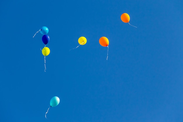 Bunte Luftballons fliegen in den blauen Himmel