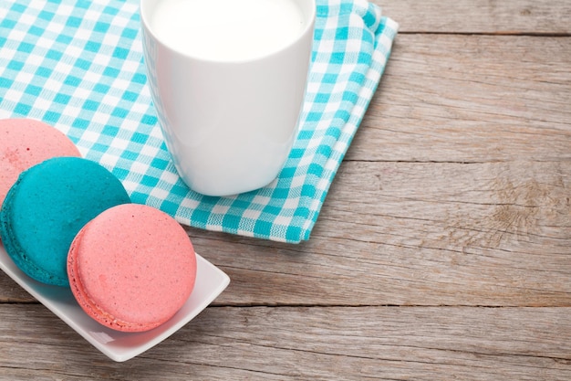 Bunte Macaron-Kekse und eine Tasse Milch