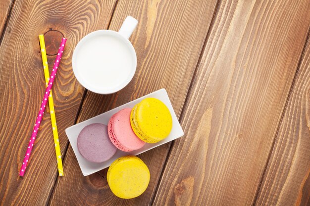 Bunte Macaron-Kekse und eine Tasse Milch