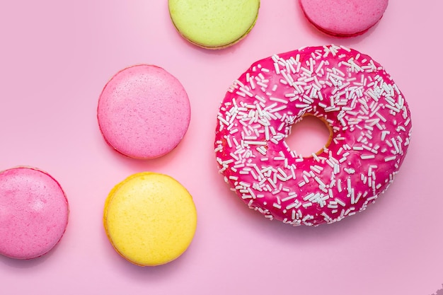 Bunte Macarons mit Donuts Bonbons auf rosa Hintergrund