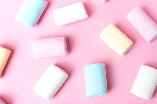 Bunte Marshmallows, die auf rosa Flatlay setzen. Marshmallow-Pastellfarben auf rosa Hintergrund.