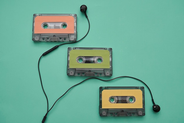 Bunte Musikkassette und Kopfhörer auf grünem Hintergrund