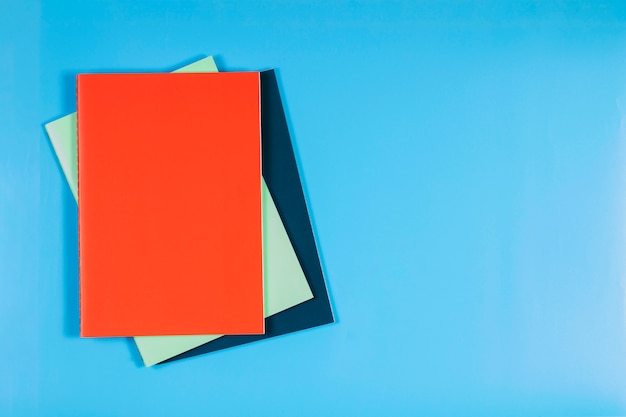 Bunte Notizbücher auf blauem Tisch. Draufsicht