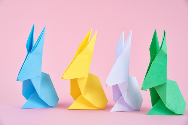 Bunte Origami-Osterkaninchen des Papiers auf rosa