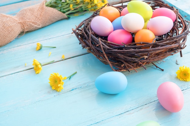 Bunte Ostereier im Nest mit Blumenstrauß