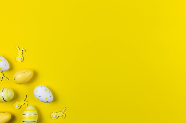 Bunte ostern bemalte Eier und Hasen auf gelbem Hintergrund Ostern Urlaub flach Konzept legen Traditionelle Dekoration für Frühlingsferien Ansicht von oben Kopieren Sie Platz