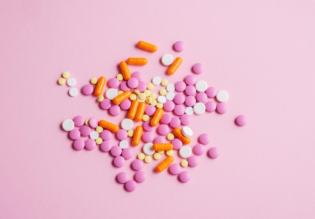 Bunte Pillen der Draufsicht auf rosa Hintergrund