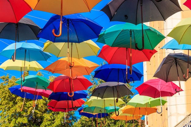 Bunte Regenschirme auf der Stadtstraße Die Stadtstraße ist mit vielen bunten offenen Regenschirmen geschmückt