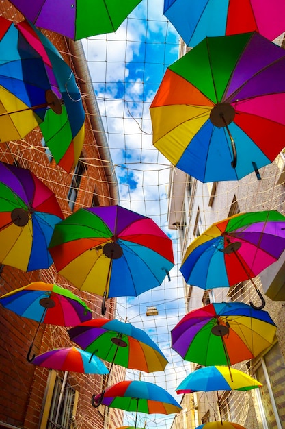 Bunte Regenschirme, die über der Straße mit blauem Himmel hängen