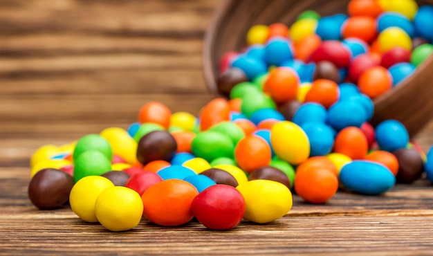 Bunte runde Bonbons verstreut aus Schüssel auf dem Tisch Nahaufnahme