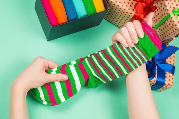 Bunte Sammlung von Baumwollsocken als Geschenk in Frauenhänden