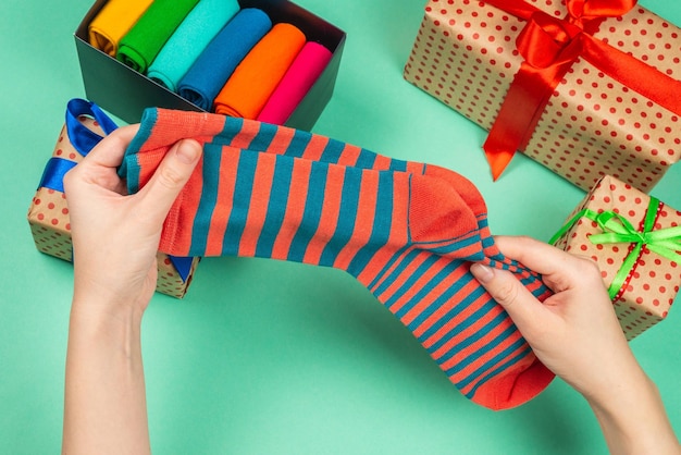 Bunte Sammlung von Baumwollsocken als Geschenk in Frauenhänden