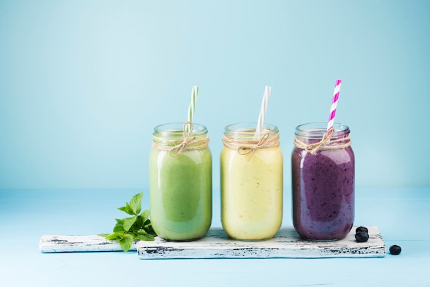 Foto bunte smoothiegläser auf blauem hintergrund