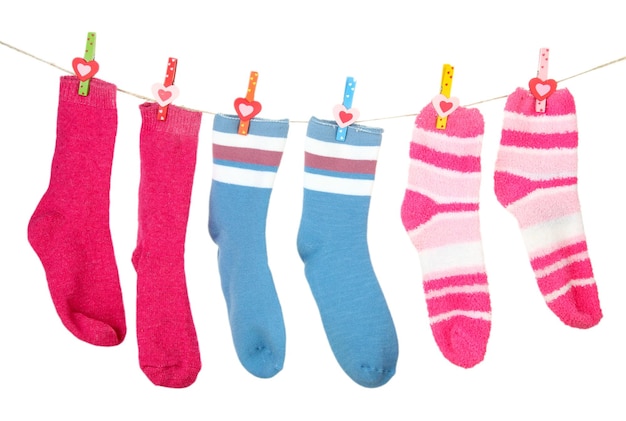 Foto bunte socken hängen an der wäscheleine, isoliert auf weiss