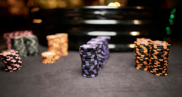 Bunte Spielsteine der Pokerchips liegen auf dem Spieltisch im Stapel Bunte Casino-Chips