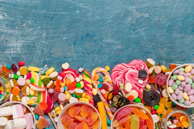 Bunte Süßigkeiten gemischt auf blauem Hintergrund