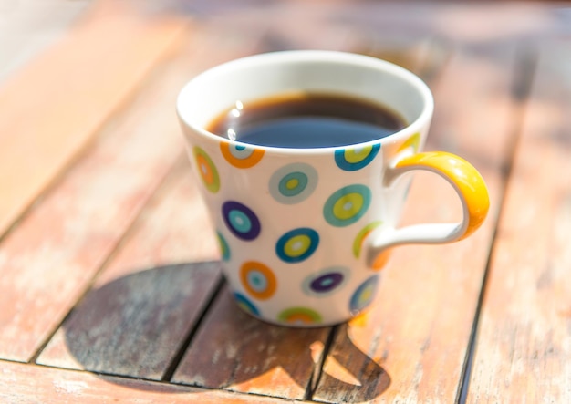 Bunte Tasse Kaffee auf Holztisch