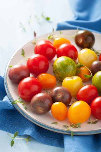 Bunte Tomaten im Teller auf blauem Stoff